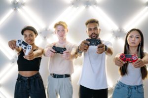 four friends each holding a PlayStation 4 controller