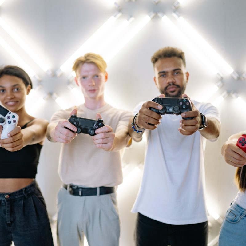 four friends each holding a PlayStation 4 controller
